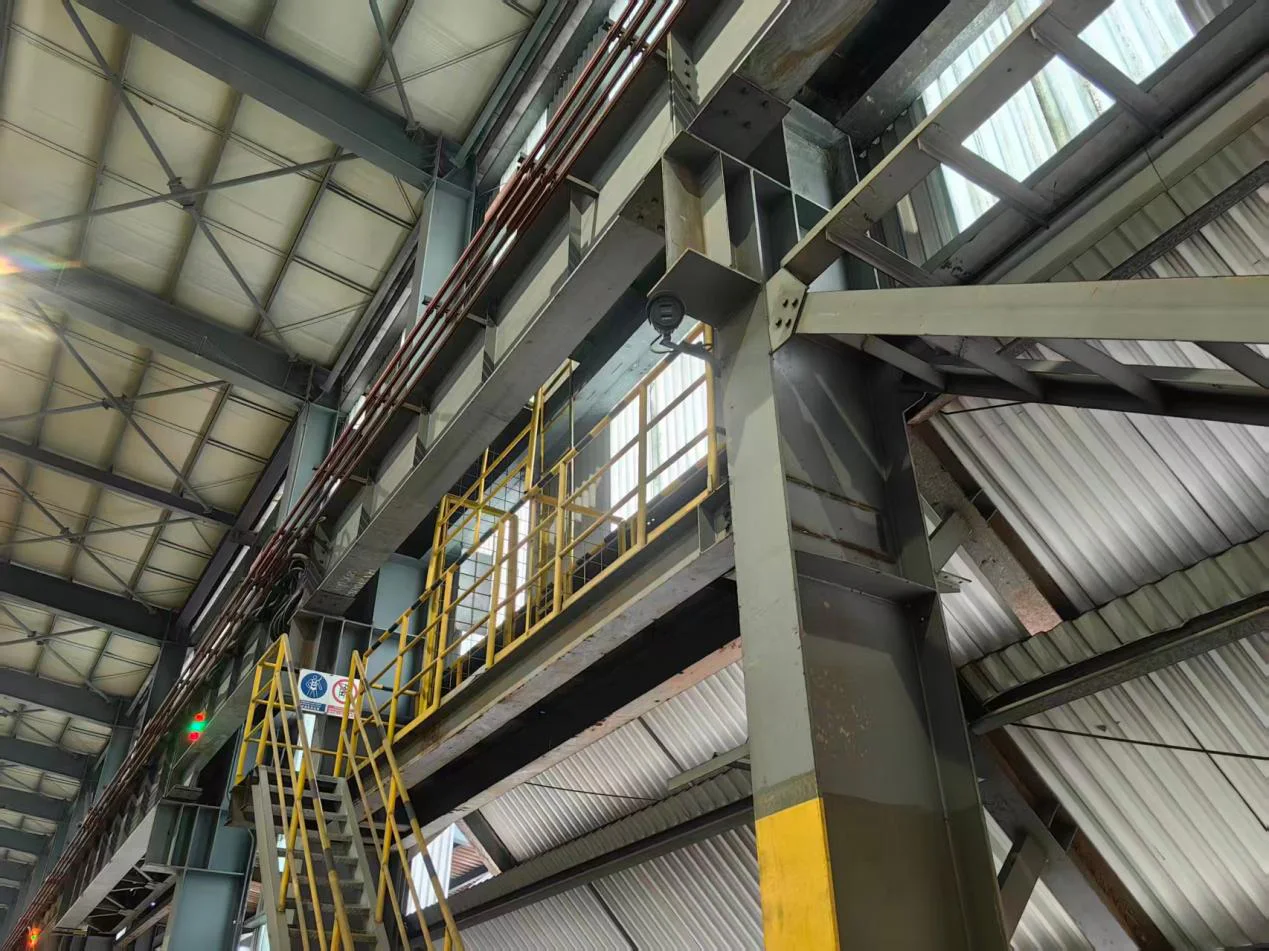 Kamera CCTV industri terpasang pada struktur fasilitas produksi berskala besar.